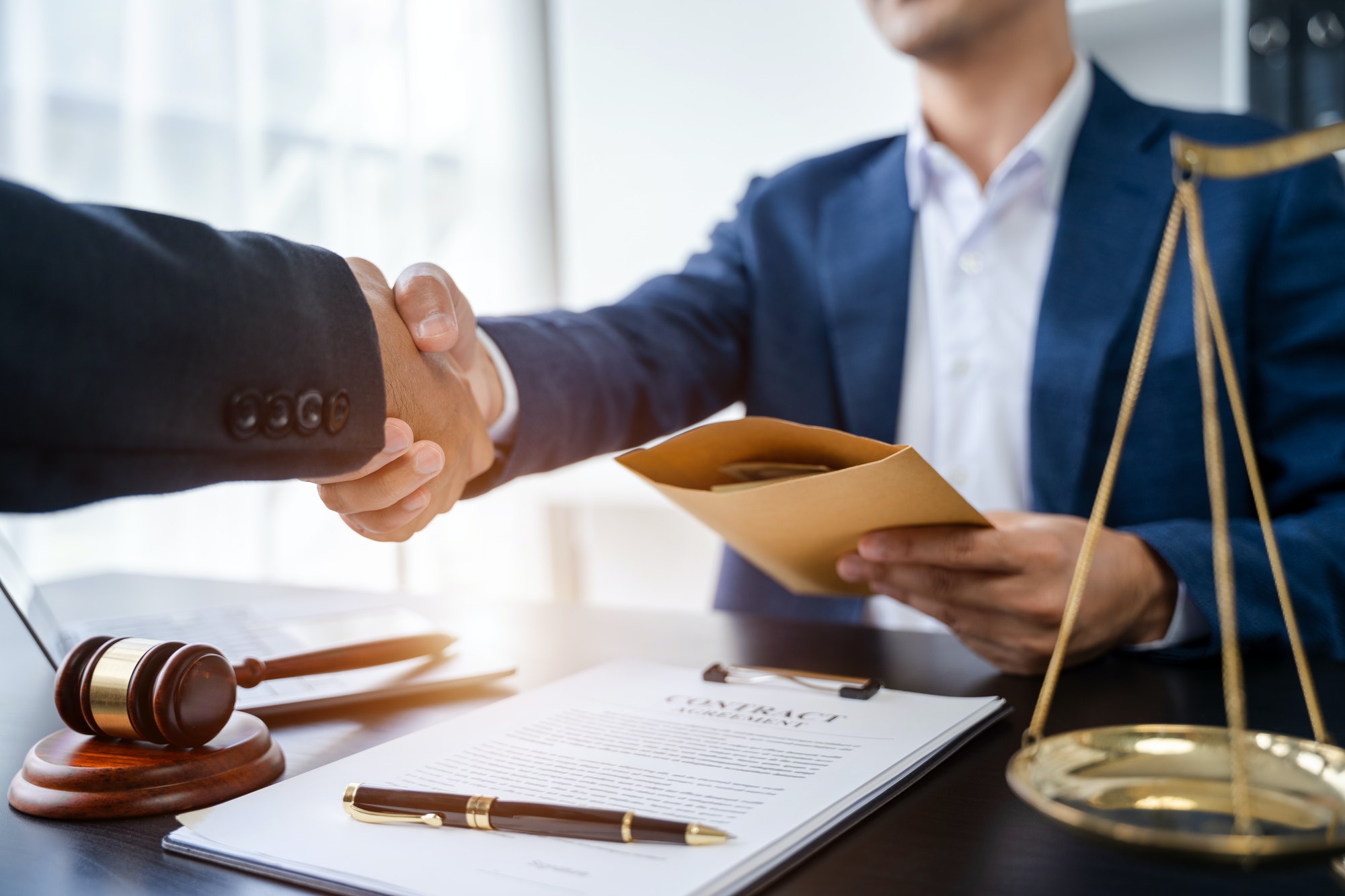 partner lawyers attorneys shaking hands after discussing a contract agreement done.